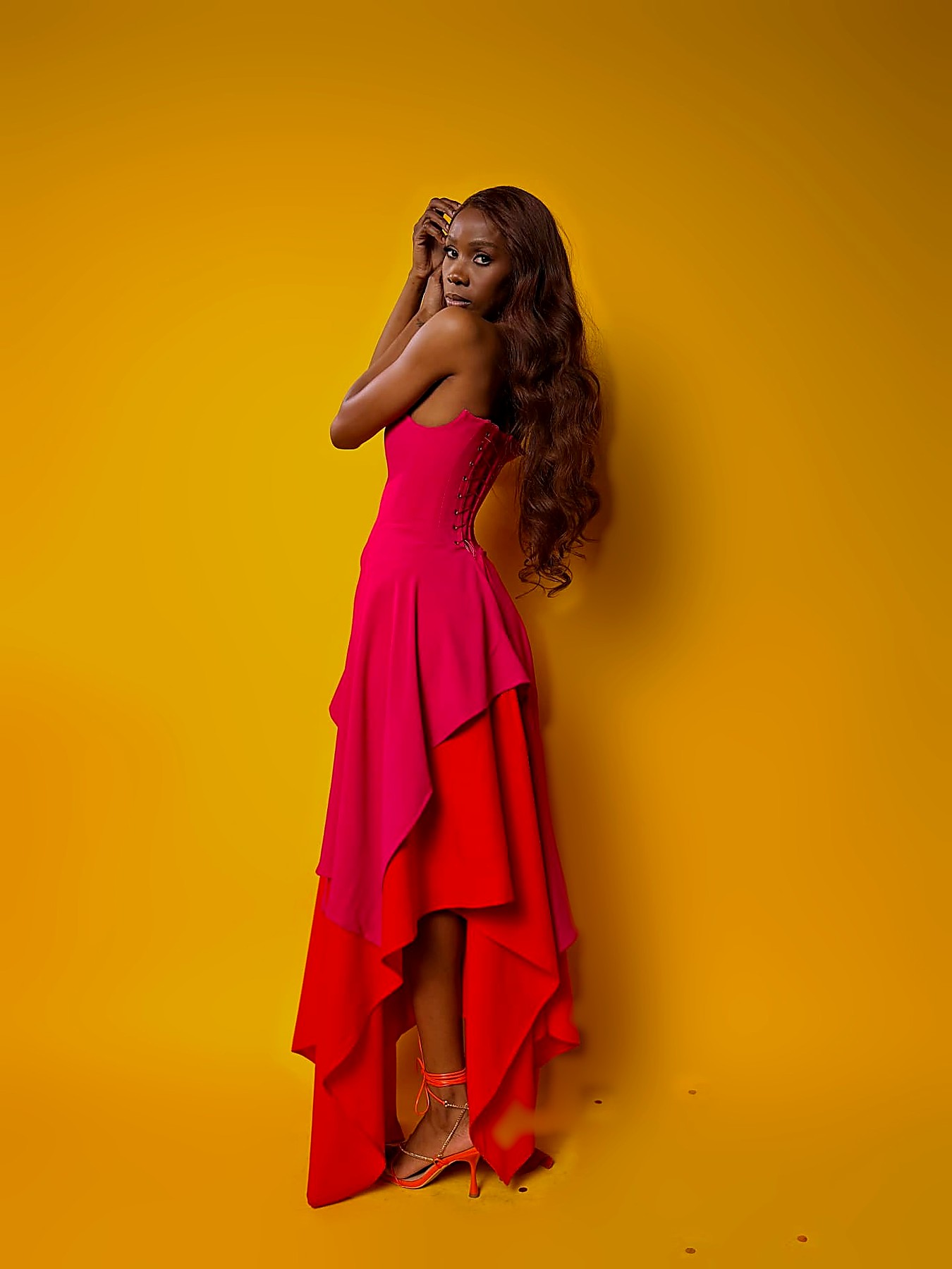 Fuchsia corset gown with laced back over a red high-low crepe skirt