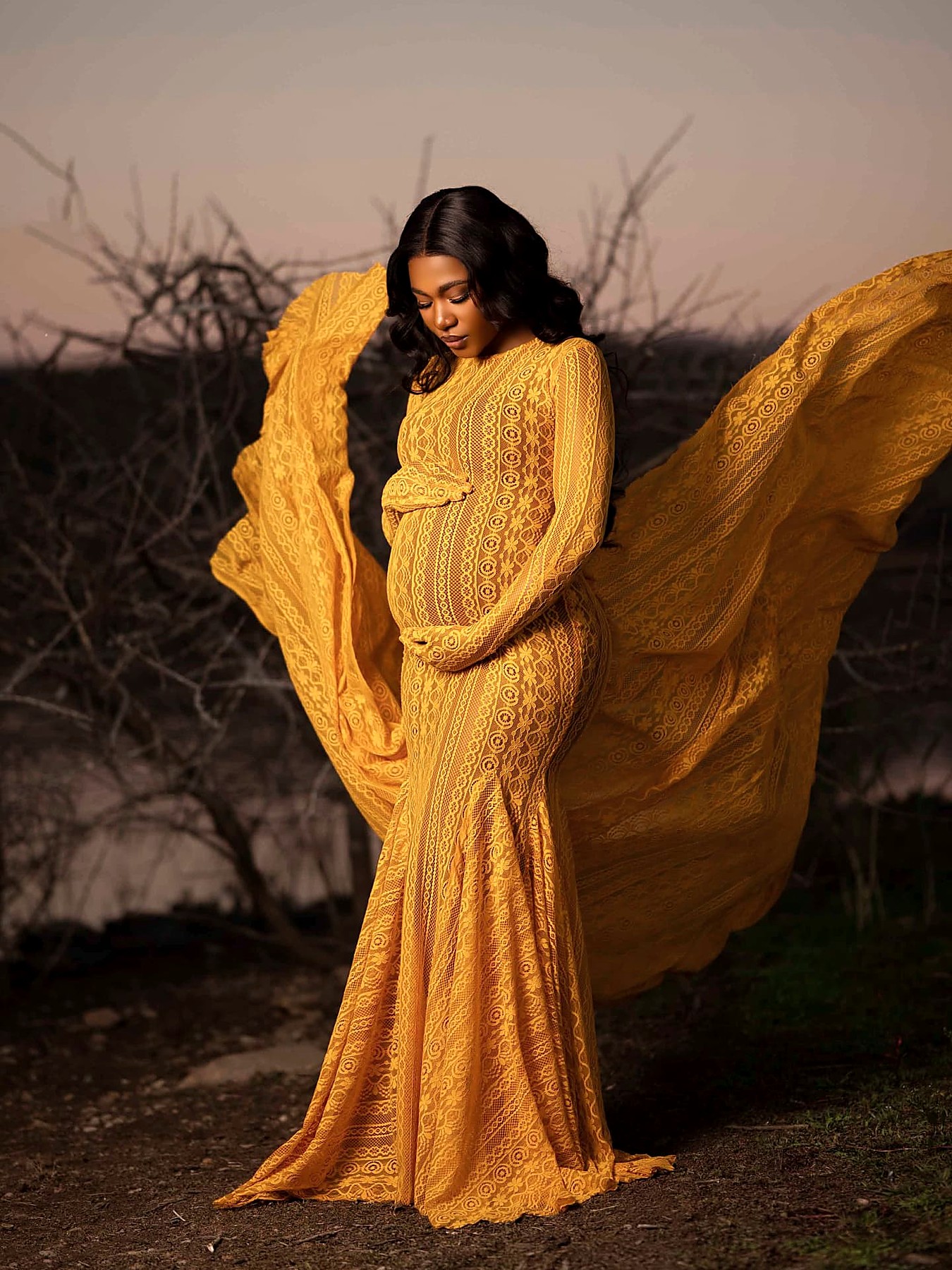 Side view of the saffron lace maternity gown with the train sweeping behind