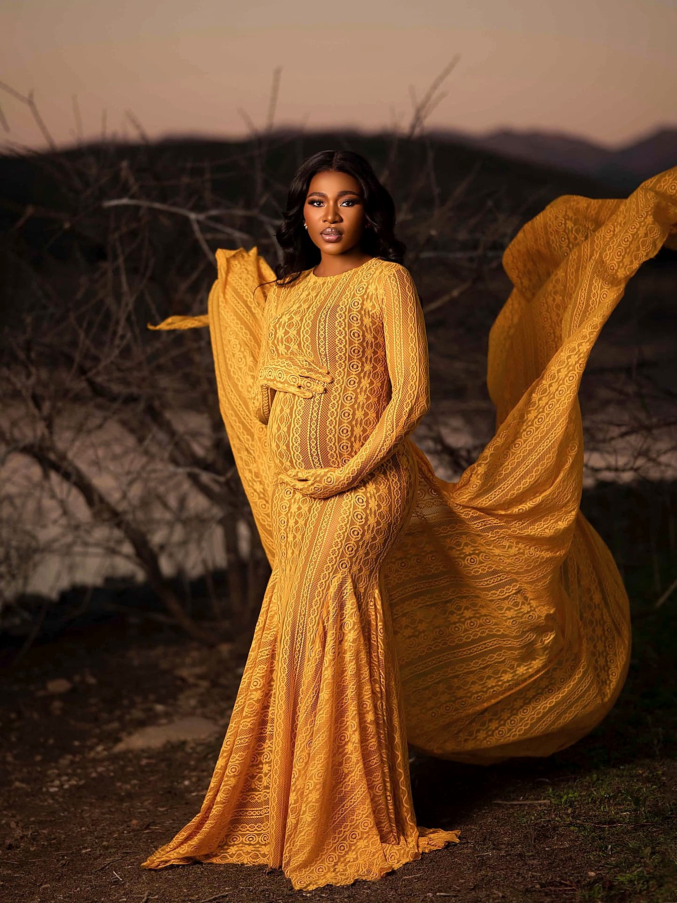 Saffron lace gown with its wide chiffon train lifted by the wind
